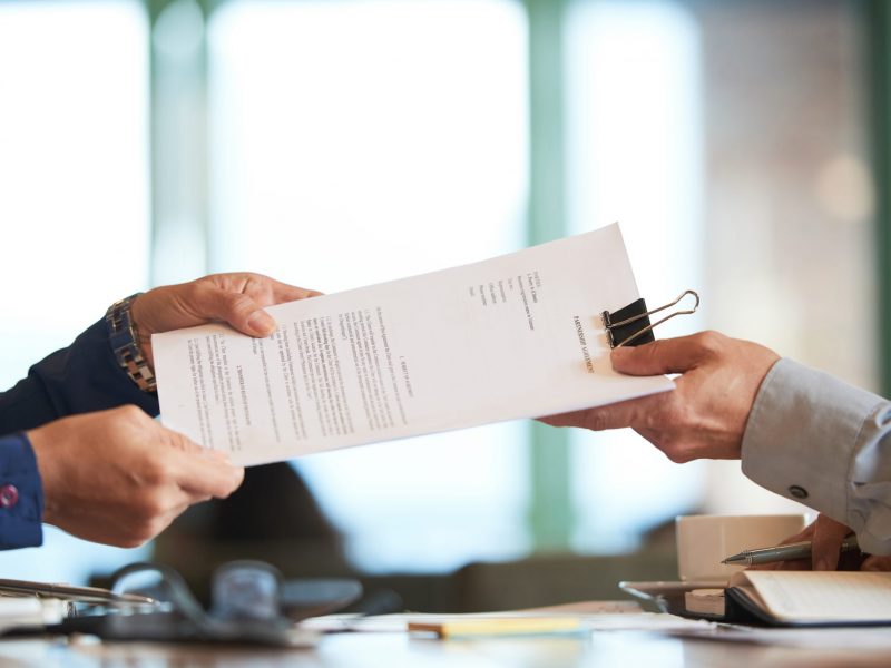 Business person giving partnership agreement to coworker